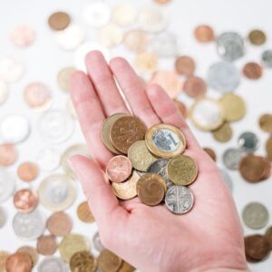 Close-up of a hand holding diverse coins, symbolizing global currency and finance.
